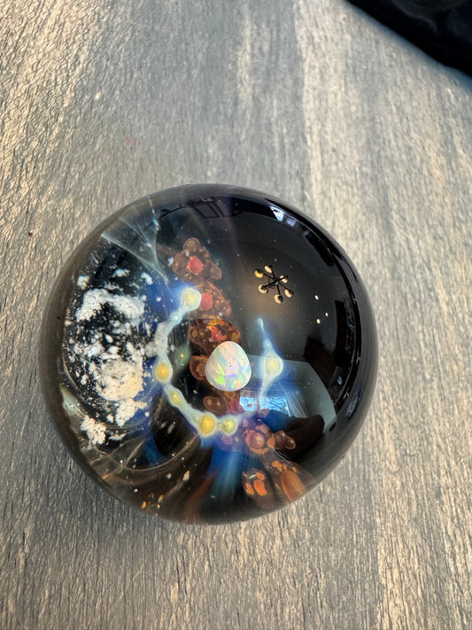 Galaxy glass memorial marble with pet ashes infused, on a wood stand